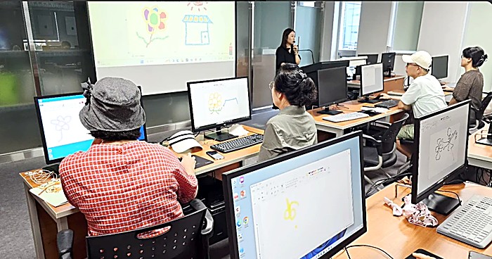 성인·시니어 디지털 역량강화교육에서 어르신들이 컴퓨터로 그림을 그리는 모습